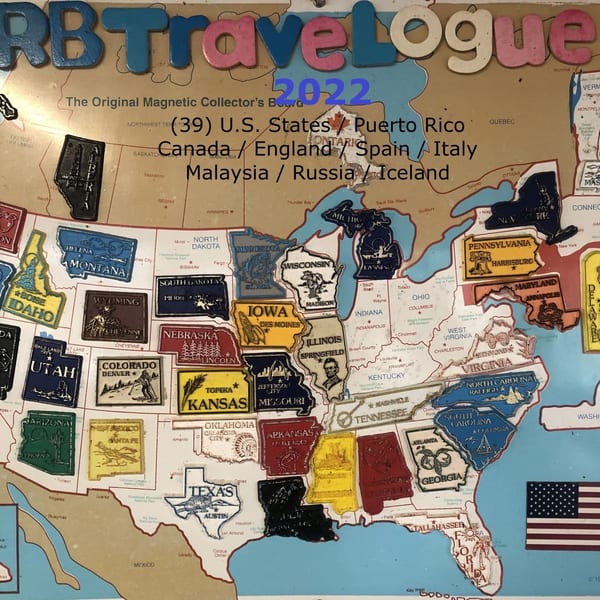 A magnetic travel map with various US states and countries represented by magnetic pieces.