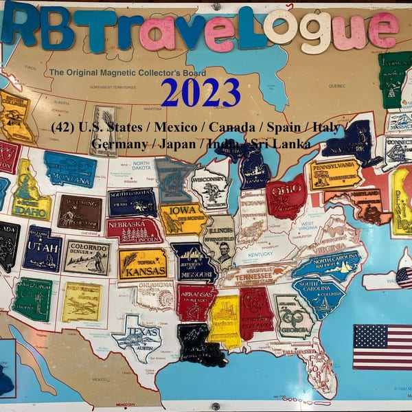 A magnetic travel board with colorful state and country magnets, including "RB Travelogue" at the top.