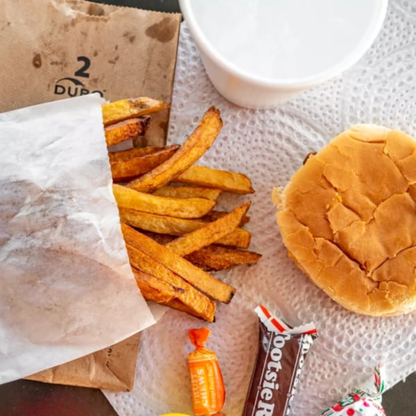 R-B Drive In burger and fries with a drink and candies on a white napkin.